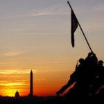 A view of a sunset and a silhouette of a flag